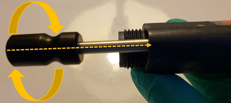 Twisting the c-clip removal tool handle to dislodge the c-clip from the push rod ejector assembly