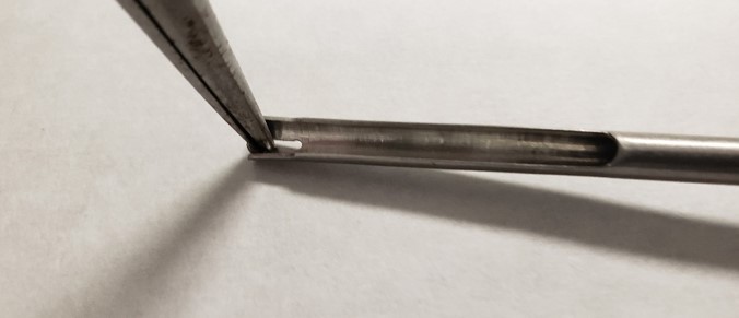 C-clip being placed into insertion tool with needle nose pliers