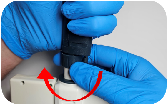 A person wearing blue gloves twists a connector with a red arrow indicating the direction of rotation.