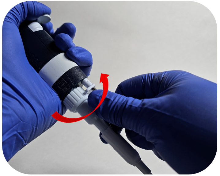 A person wearing blue gloves reattaches the tip ejector to the ejector assembly; a red arrow indicates the direction of rotation.