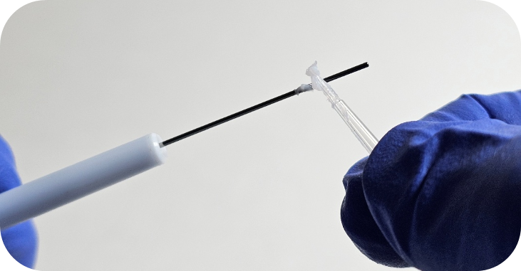 A gloved hand greasing a Pipetman piston